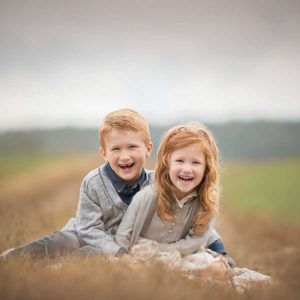 Photo of a brother and sister dressed stylishly on a farm