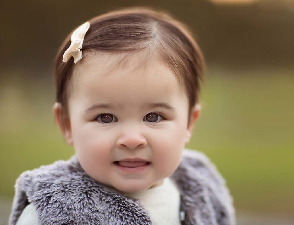 adorable girl fur vest Adorable baby girl standing in a park in Greenwich CT