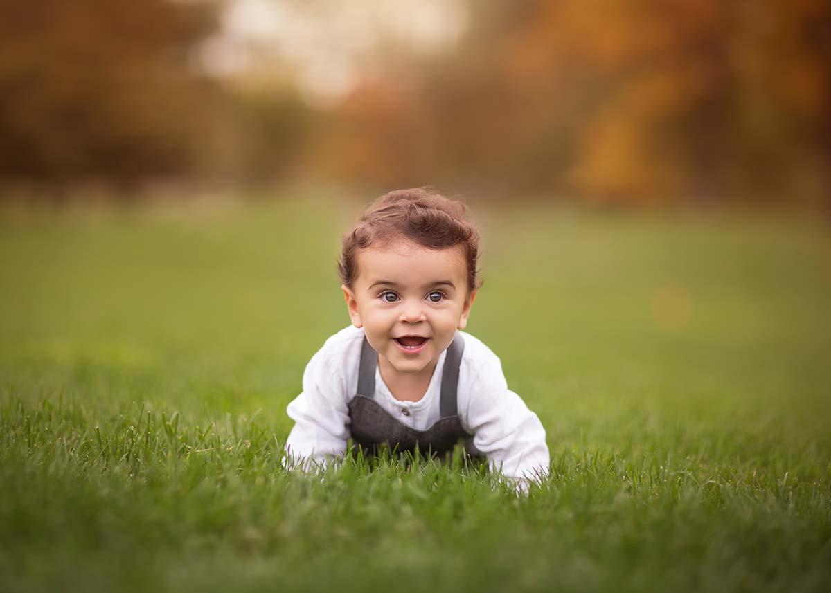 Baby boy crawling in grass in Denver, CO