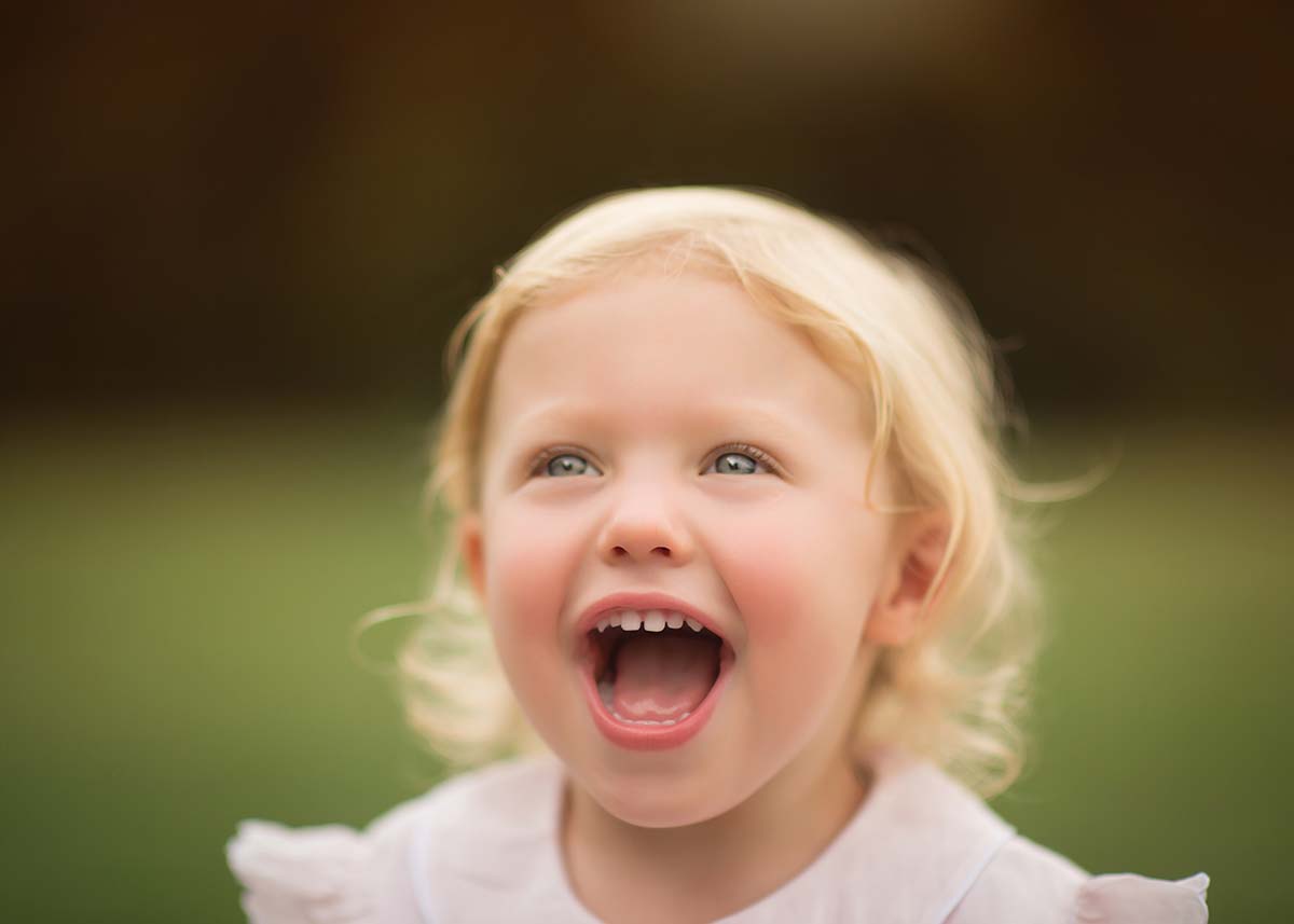 Baby girl laughing outdoors