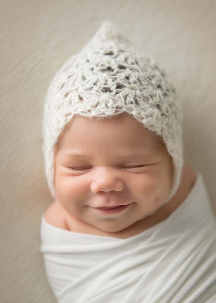 Smiling infant in a bonnet