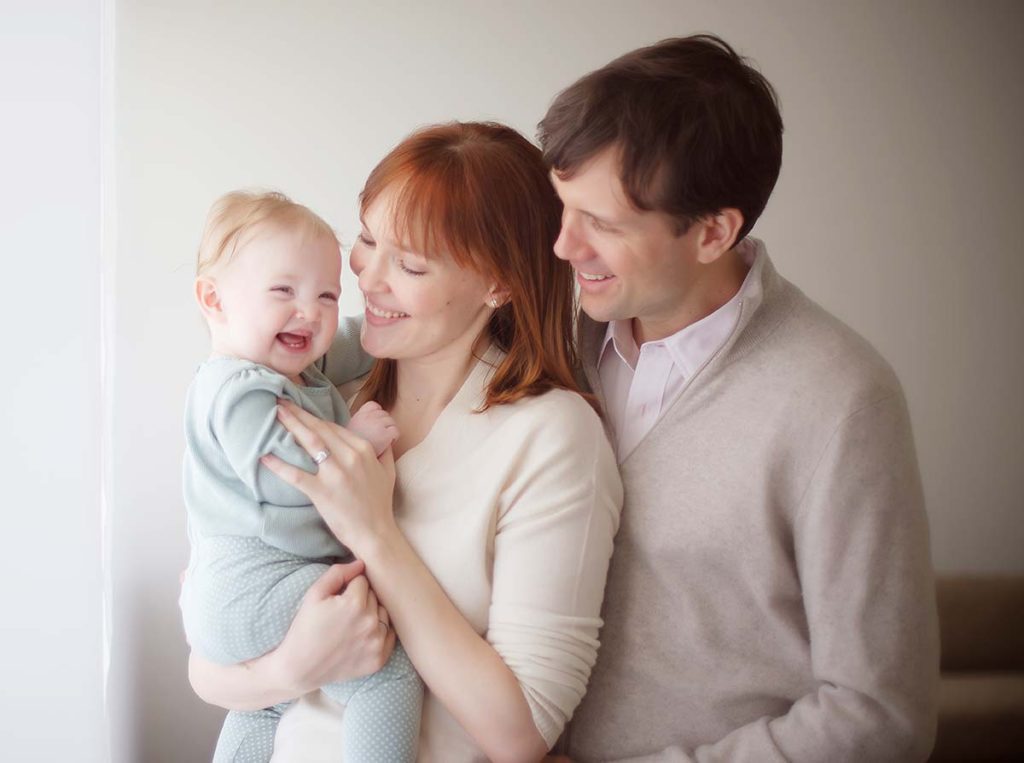 beautiful family laughing baby Beautiful family holding a smiling baby in Scarsdale NY