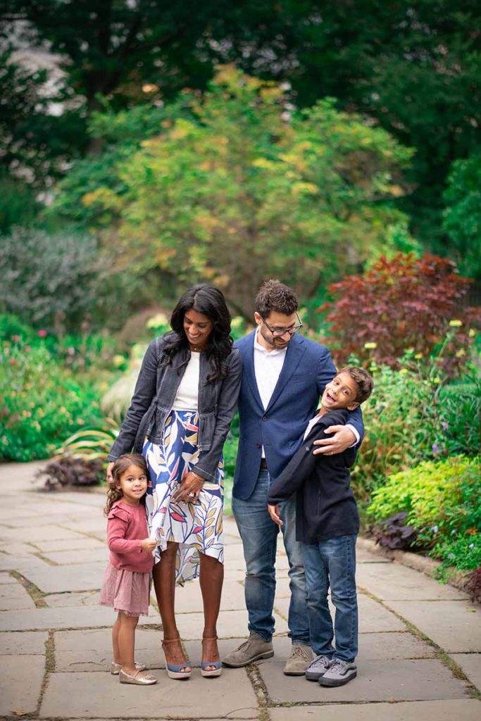 Children laughing with their parents at a garden in this stunning family photo taken in Westchester county NY