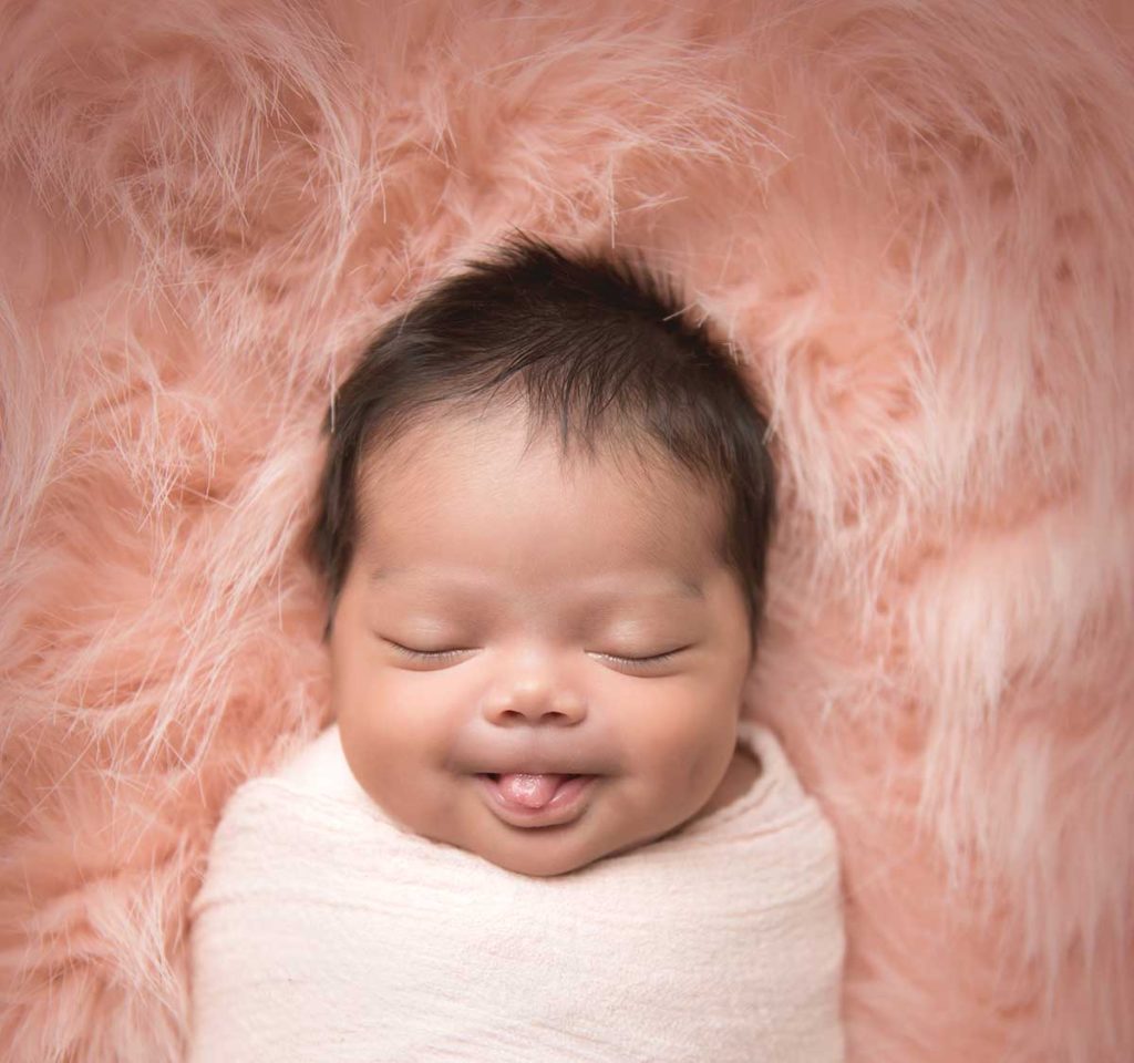 Cute baby from Connecticut smiling at the newborn photographer