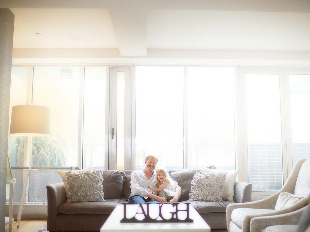 couch father cuddling daughter Happy father cuddling his daughter on a couch in their Scarsdale New York home