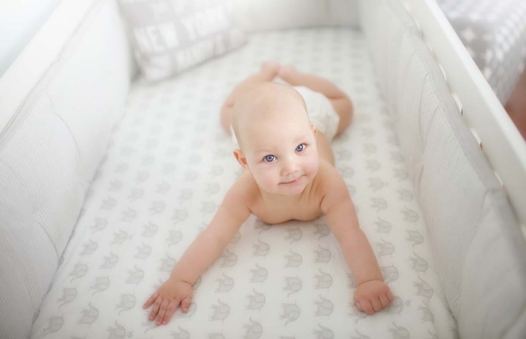 Baby with blue eyes laying in his crib