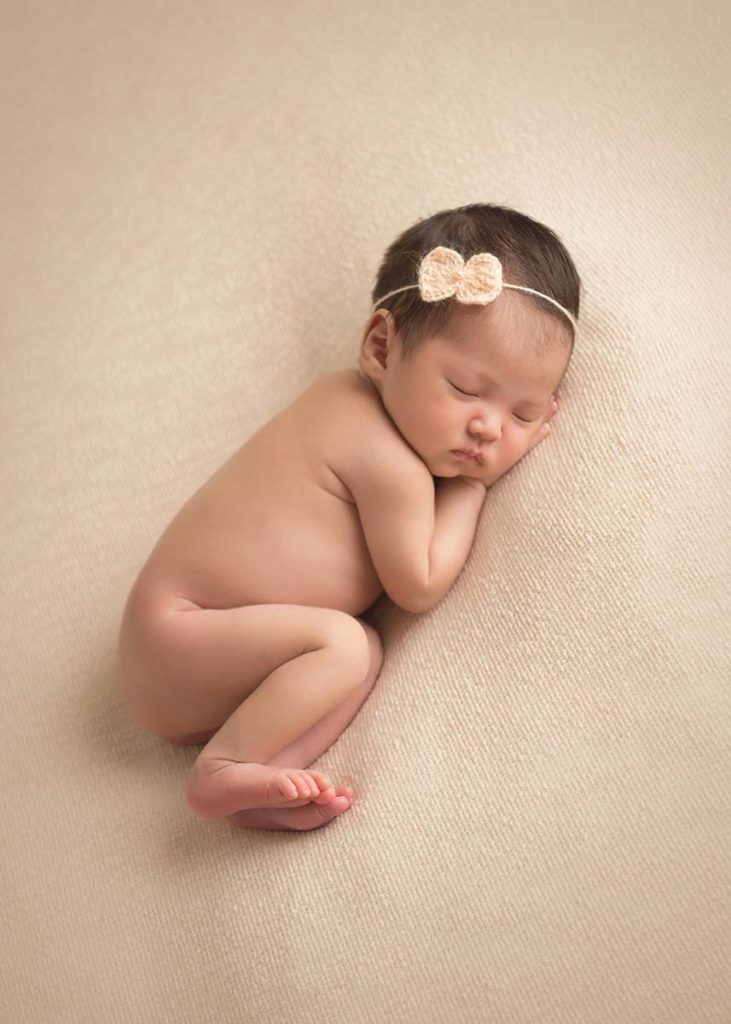 Newborn baby with curled up feet sleeping in a photo studio in Westchester Co, NY.