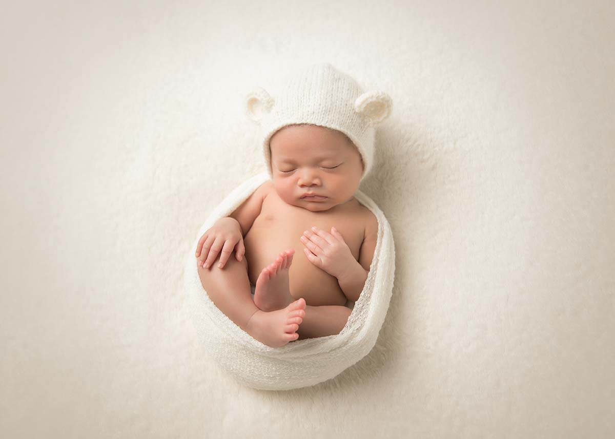 Handsome newborn boy sleeping in a swaddle in this timeless photo taken in Denver, CO.