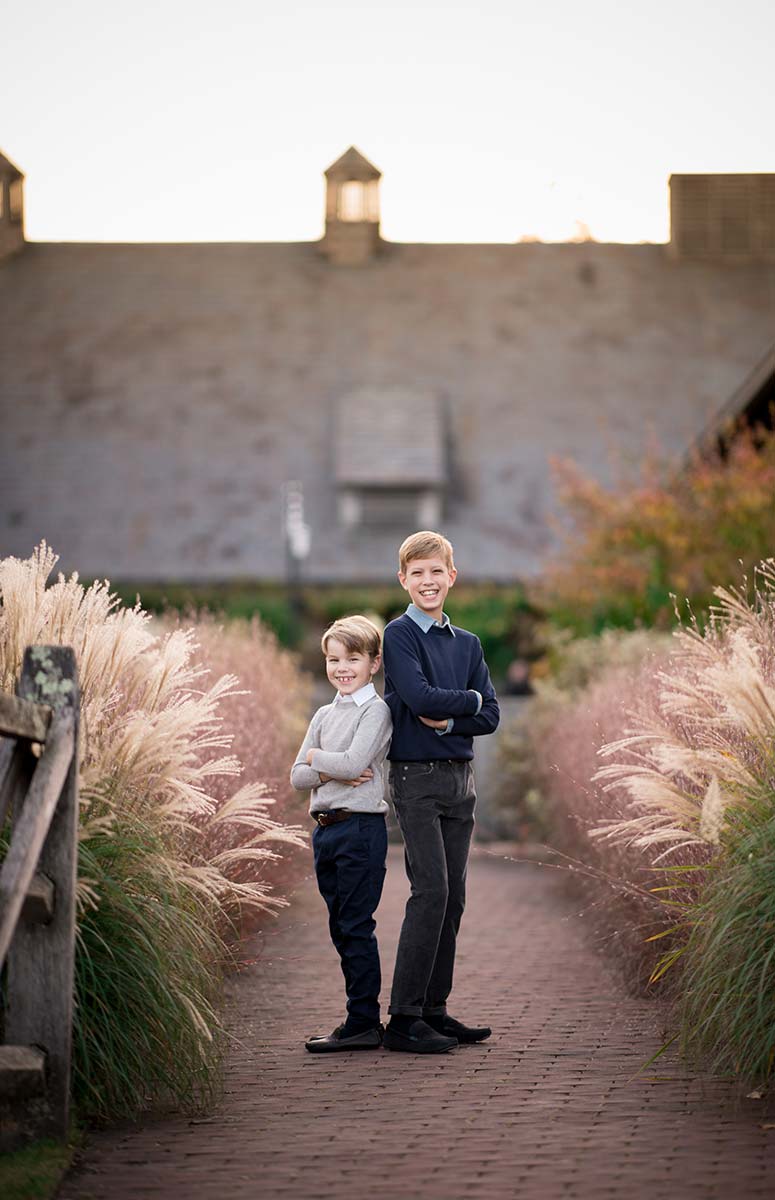 Two brothers crossing their arms in this candid sibling photo taken in a Westchester NY farm