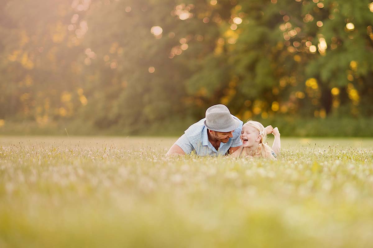 A timeless moment shared between a father and his baby girl in a clover field near Denver, Colorado.