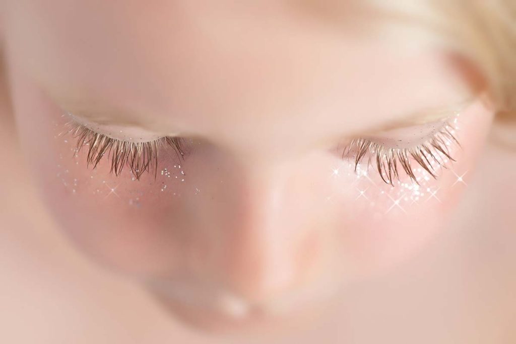 Closeup of girl's eyelashes with sparkles