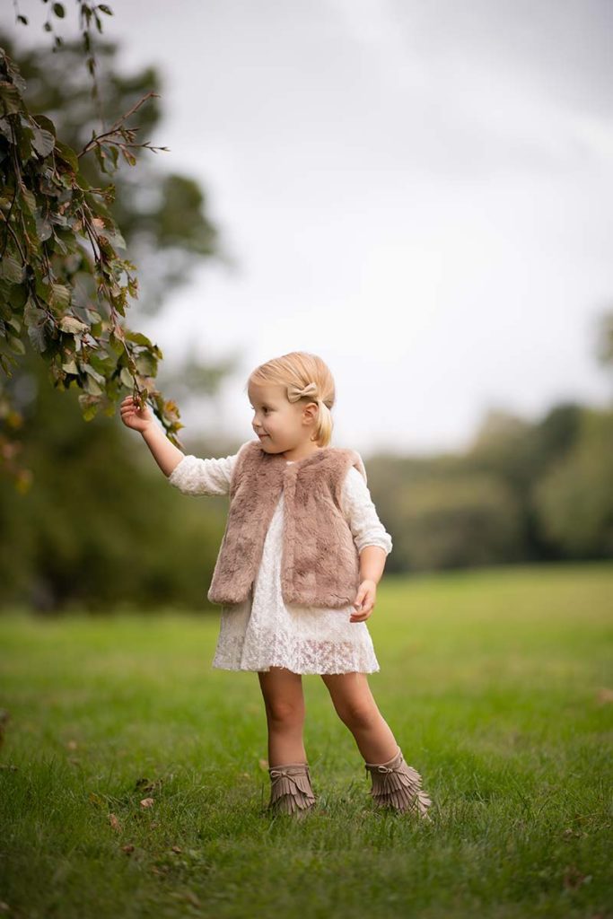 girl picking leaves Girl in a cute outfit picking leaves off a tree in Westchester county park