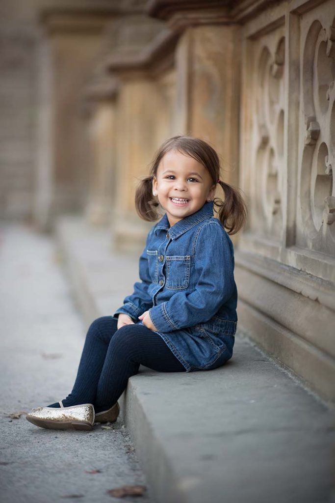 girl pigtails sitting stone wall Sweet baby girl with pigtails posing for a photo at a park in Rye, New York.