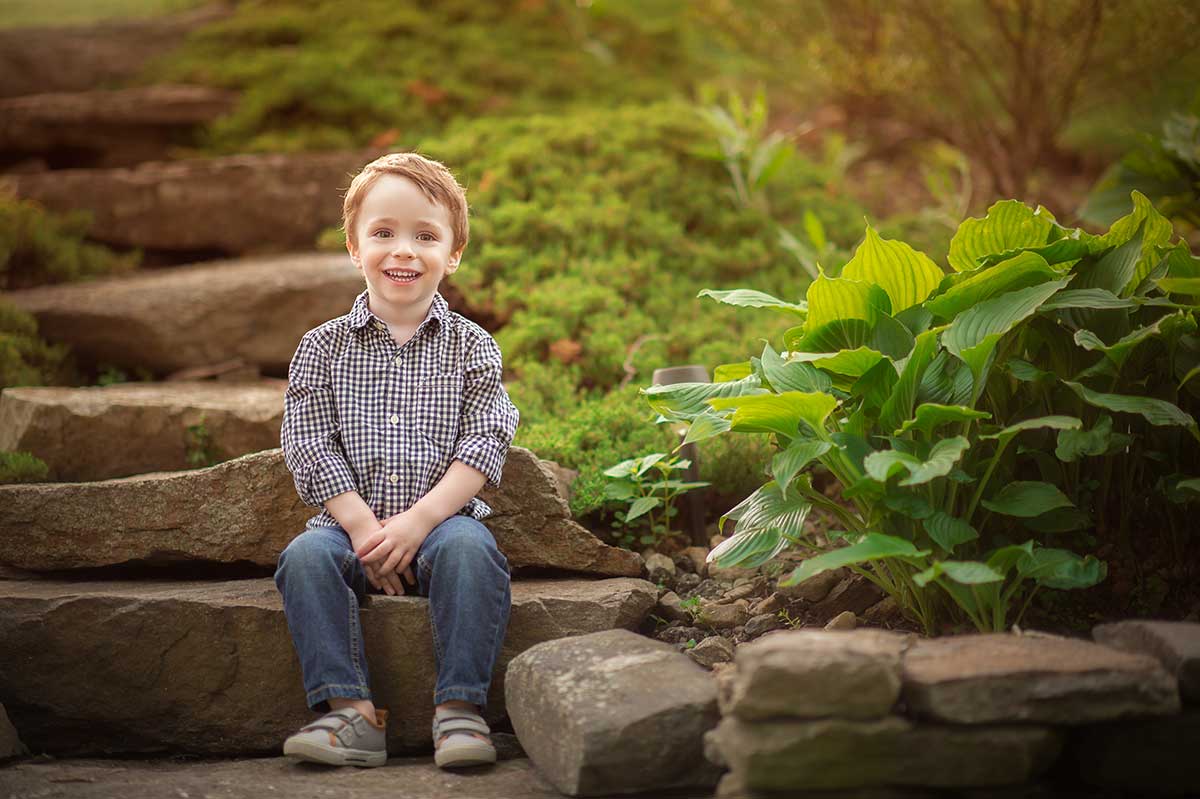 Lifestyle photoshoot in Denver of a cute boy sitting in his backyard