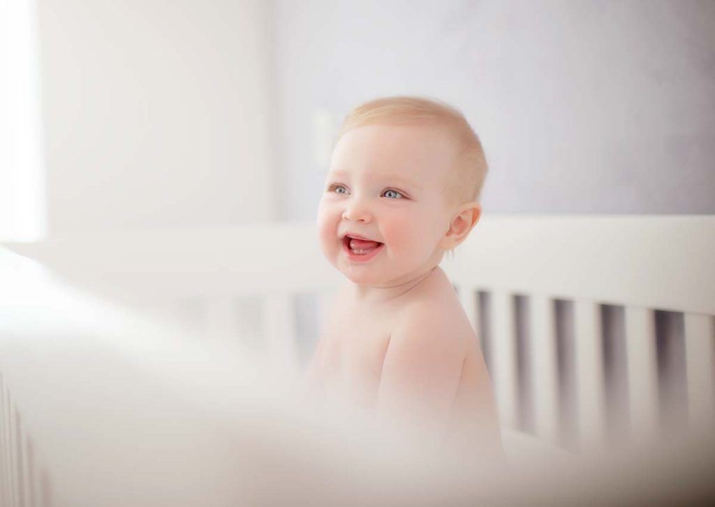 baby laughing in a crib