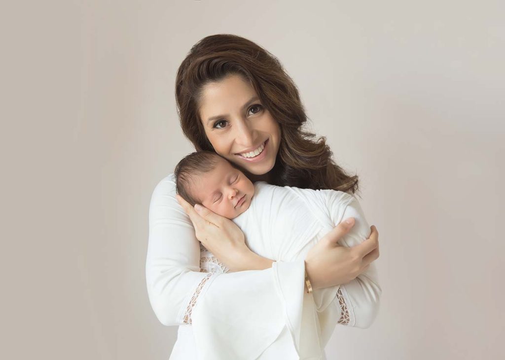 Smiling mother holding her baby in this newborn photo