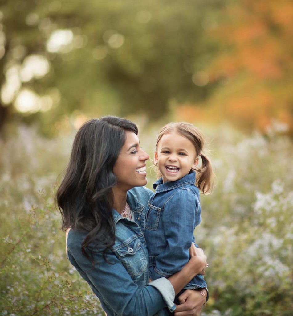 mother daughter hugging fall foliage Mother holding her beautiful daughter amongst autumn leaves