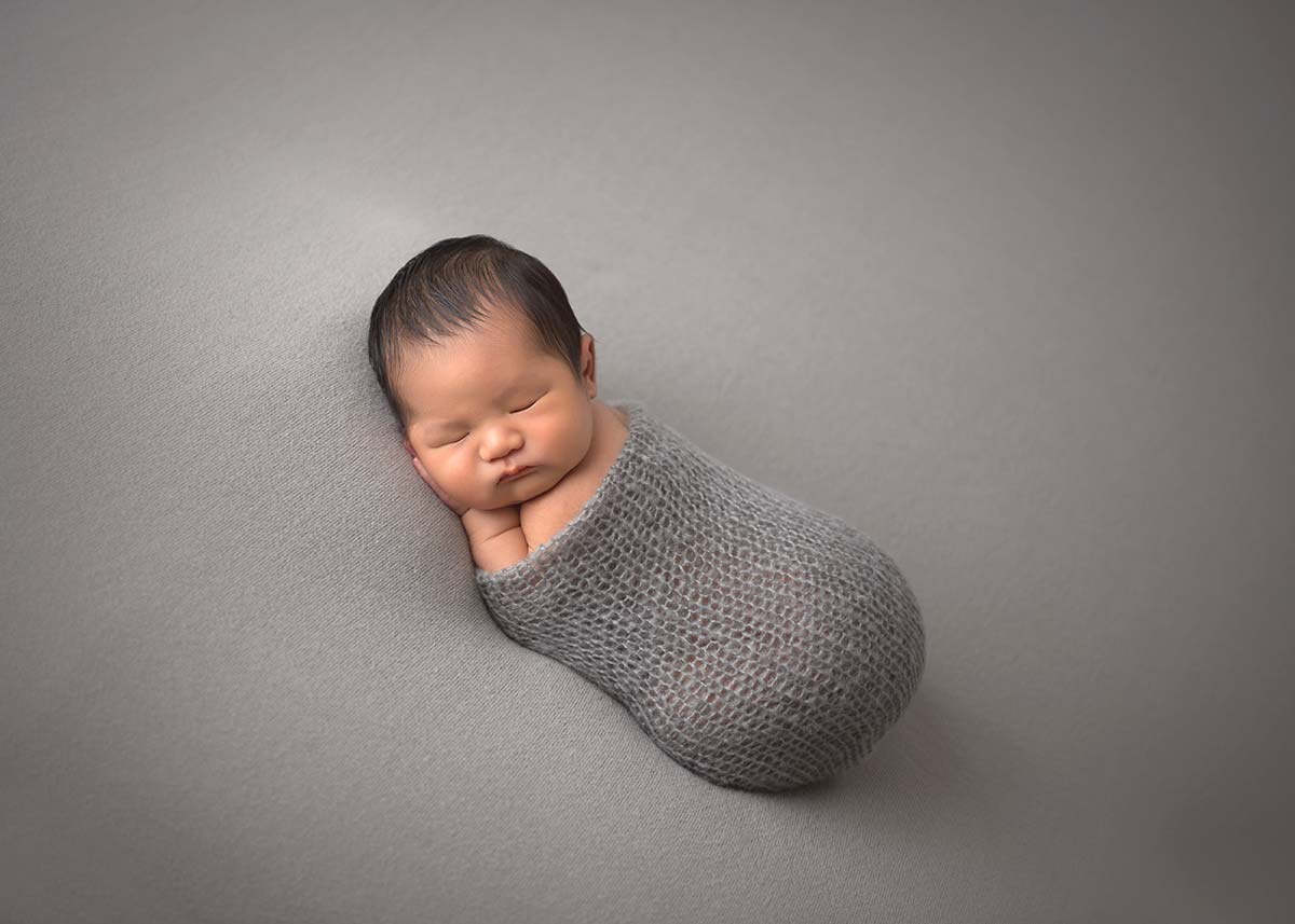 Infant baby sleeping on a blanket at a photography studio