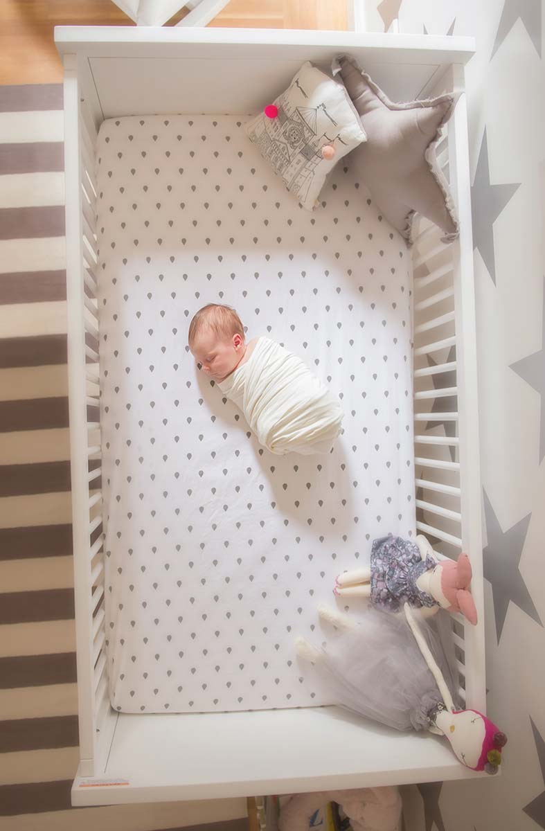 Modern crib with a sleeping newborn