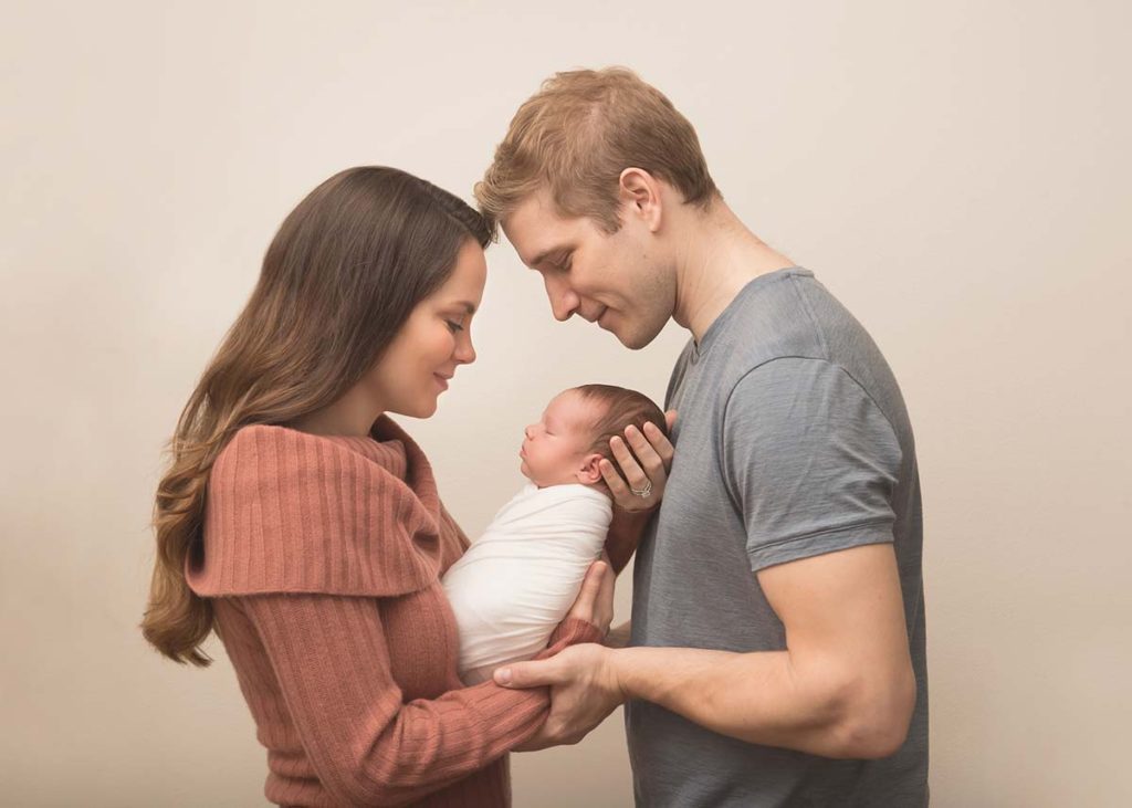 Joyous parents holding their infant for a photo