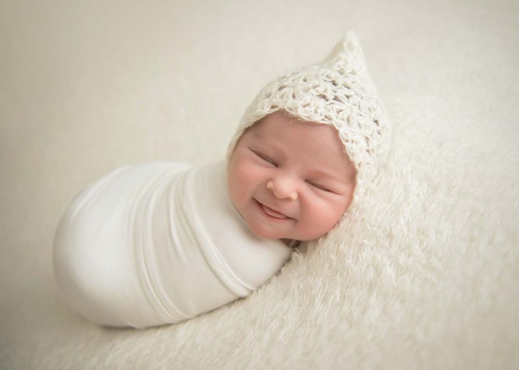 Incredible newborn photo of a smiling infant