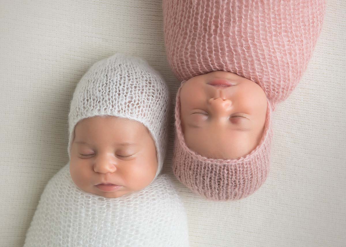 Two newborn twins sleeping together in this amazing photo