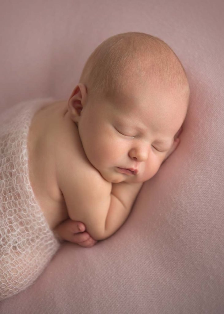 Stunning newborn baby sleeping on a blanket at a photo studio in Greenwich Connecticut
