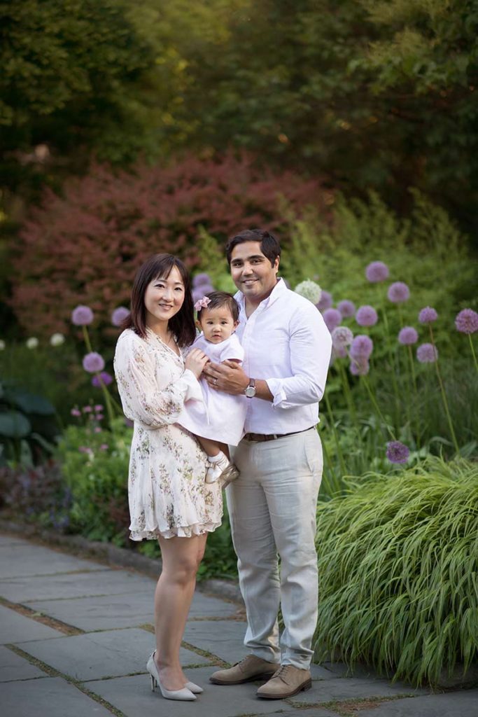 purple flowers family photo shoot Family photo with a mother, father and their baby girl taken in a flower garden.