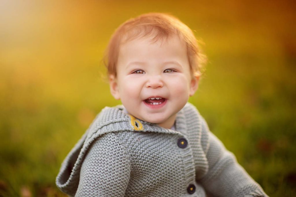 Closeup photo of a smiling toddler during a glowing sunset