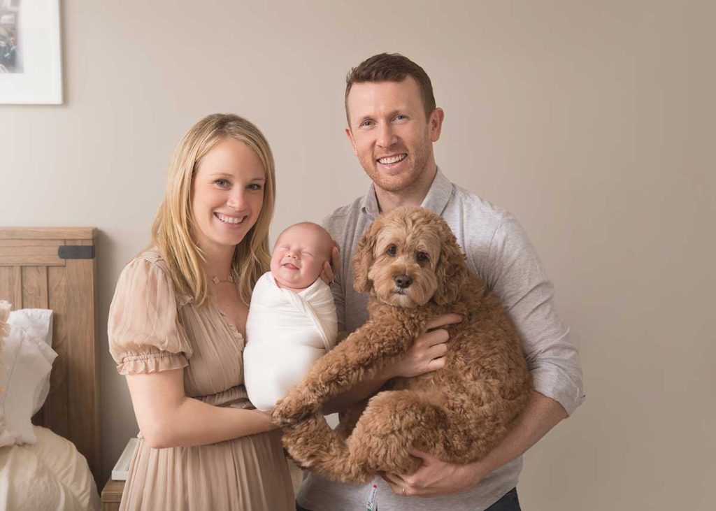 Cute smiling newborn baby in a family photo