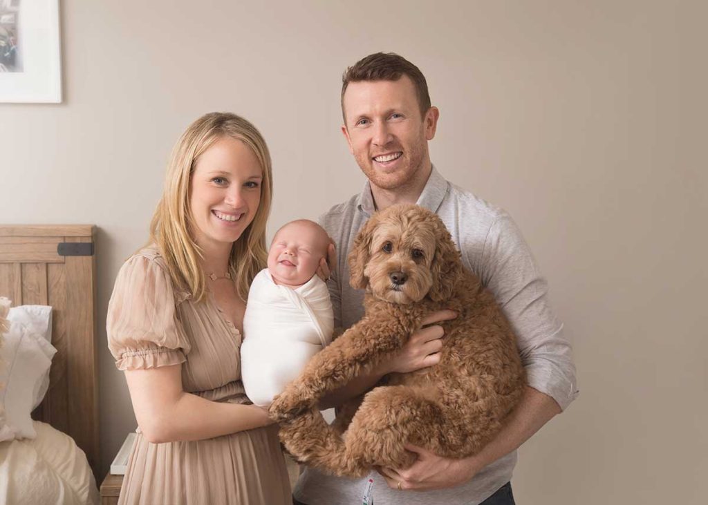 smiling newborn dog parents Cute smiling newborn baby in a family photo