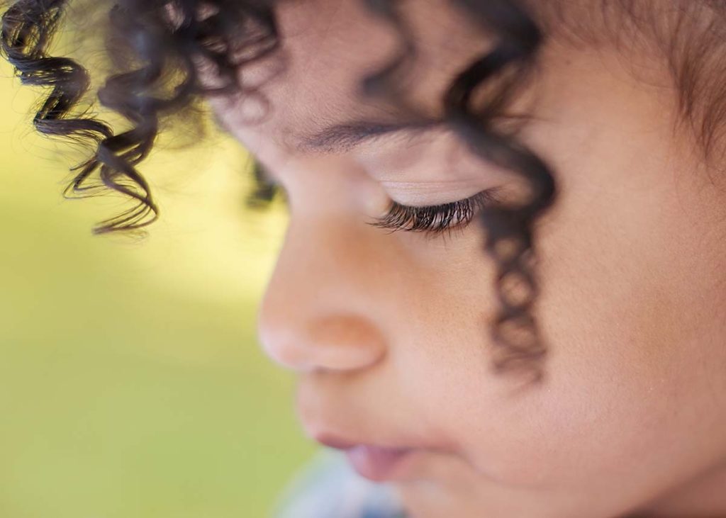 Closeup of eyelashes on young girl with black curly hair
