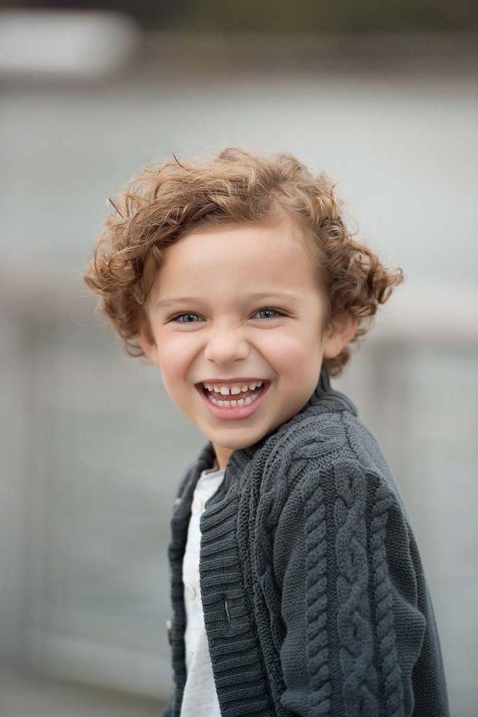 Handsome young boy smiling during a baby photoshoot in Connecticut.