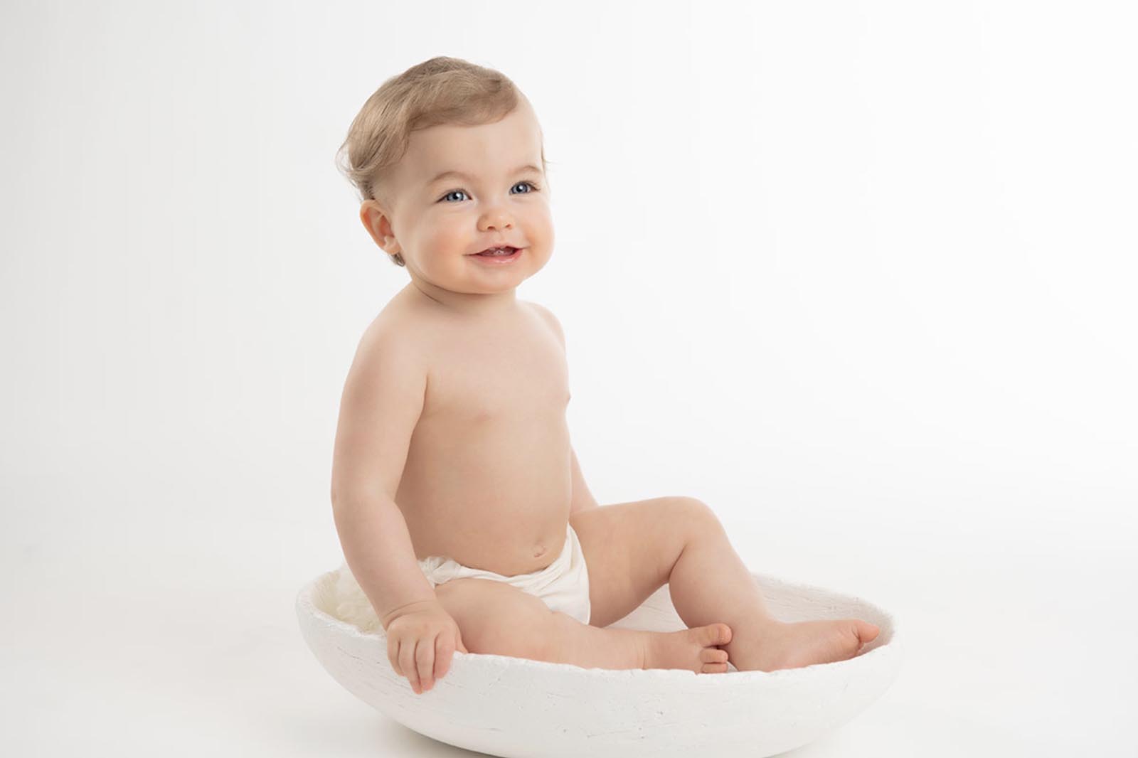 Baby smiling happily at a photo studio