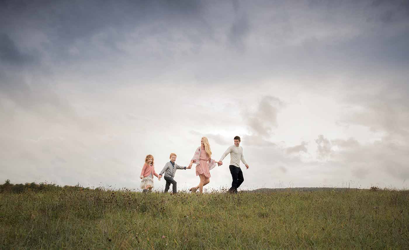 Family photo walking in a meadow near Denver
